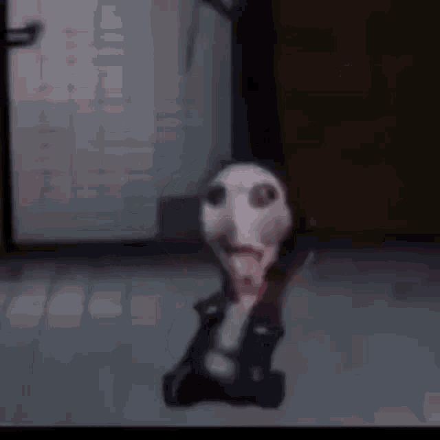a stuffed animal with a bloody face is sitting on the floor .