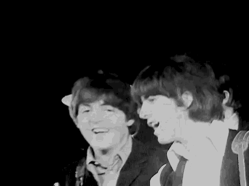 two men are standing next to each other on a stage and smiling .