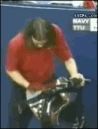 a man in a red shirt is riding a bike in front of a sign that says navy tv