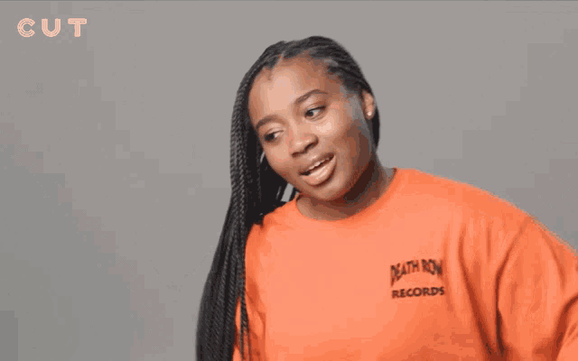 a woman wearing an orange death row record sweatshirt
