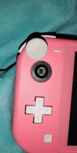 a pink nintendo switch controller with a white cross on it