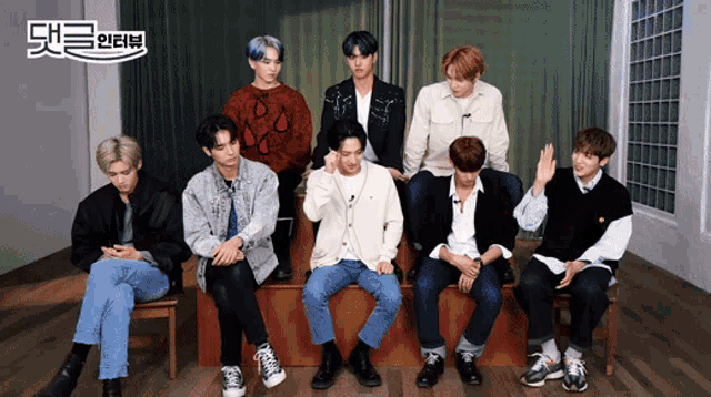 a group of young men are sitting in a room with a sign that says ' ae '