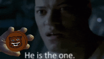 a man is holding a cookie with a leopard face on it and the words he is the one behind him