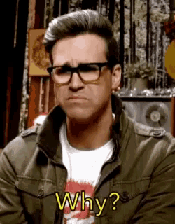 a man wearing glasses and a t-shirt is asking why .