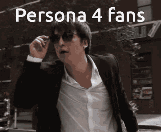 a man in a suit and white shirt is walking down a street with the words persona 4 fans written above him