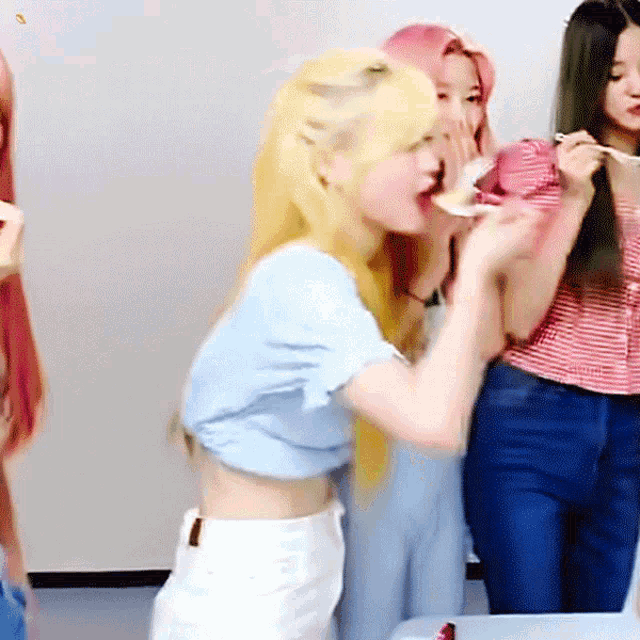 a woman with blonde hair is eating a spoonful of food