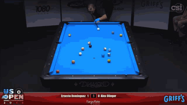 a pool table with a blue cloth and a person holding a cue
