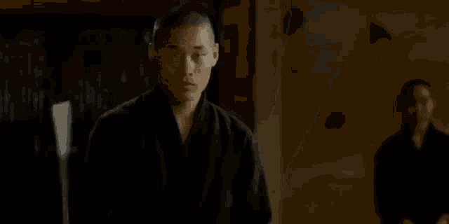 a man in a black shirt is holding a gun in his hand .