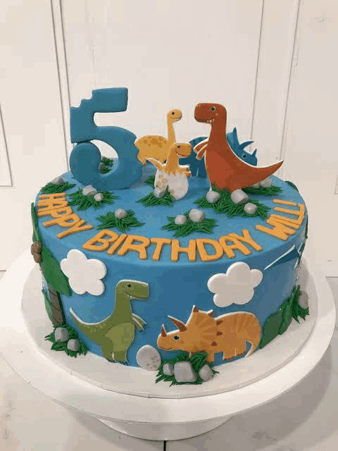a birthday cake with dinosaurs on it and the number 5 on top