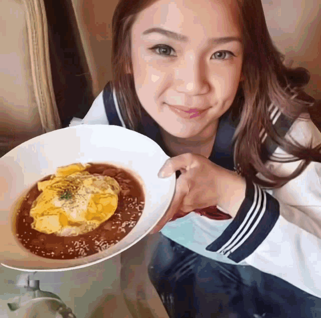 a woman in a sailor uniform holds a plate of food
