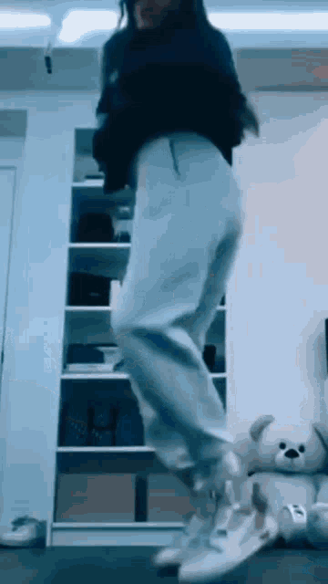 a woman in a black shirt and white pants is dancing