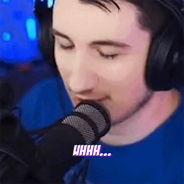 a man is wearing headphones and singing into a microphone with the word uhhh visible