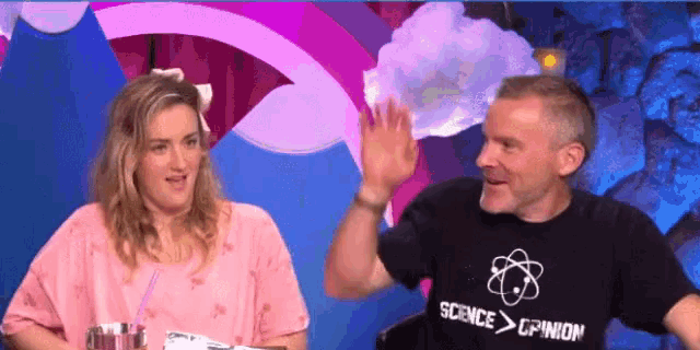 a man wearing a shirt that says science > opinion waves to a woman