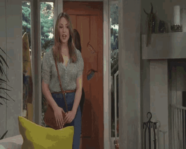 a woman is standing in front of a door with a surfboard on it .