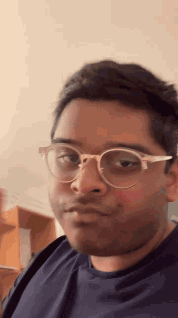 a man wearing glasses is making a funny face