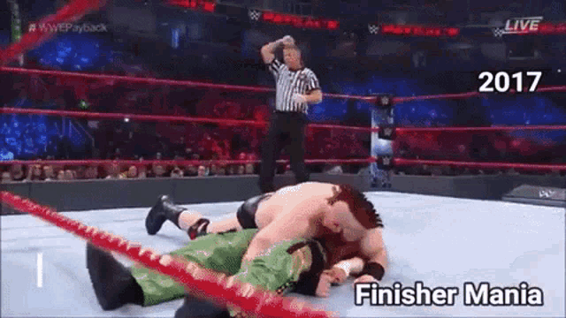 a wrestler is laying on the ground in a finisher mania match