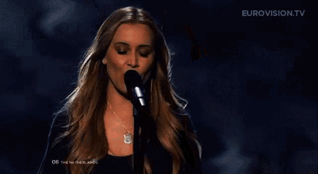 a woman singing into a microphone on eurovision