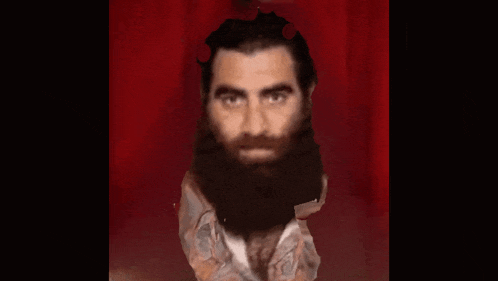 a man with a beard is standing in front of a red background
