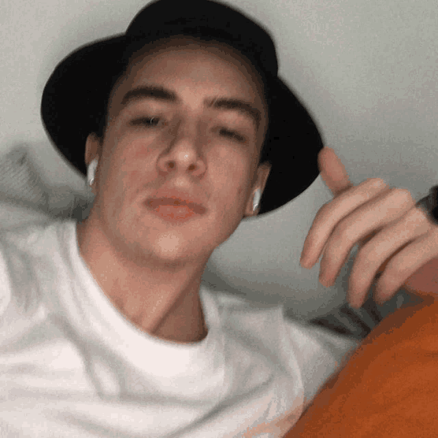 a young man wearing a hat and ear buds