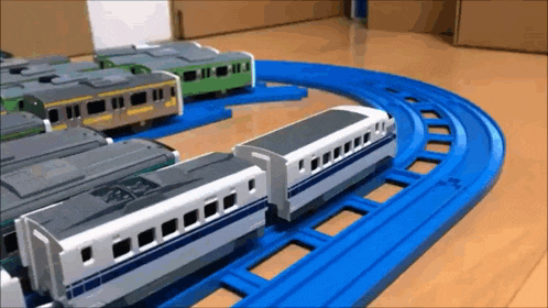 a toy train is going down a track with other trains