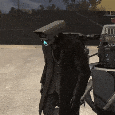 a man in a suit with a camera on his head stands next to a camera