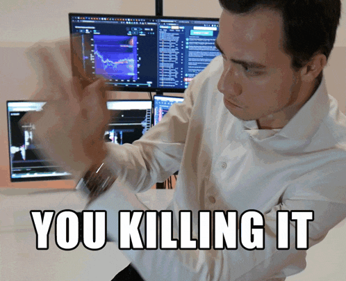 a man in a white shirt is standing in front of a computer screen with the words " you killing it " above him