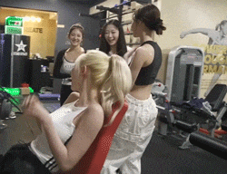 a group of women are in a gym with a sign on the wall that says ' rm '