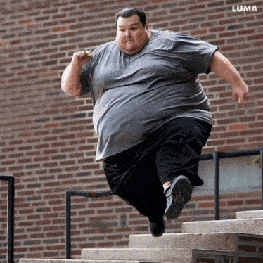 a man is jumping up a set of stairs in front of a brick building