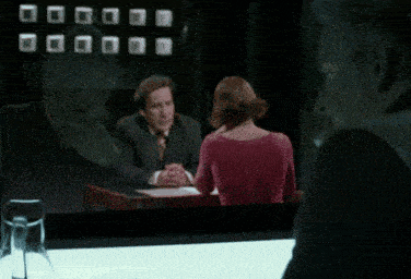 a man and a woman are sitting at a table talking to each other