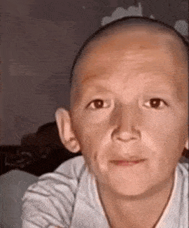 a close up of a child 's face with a bald head .