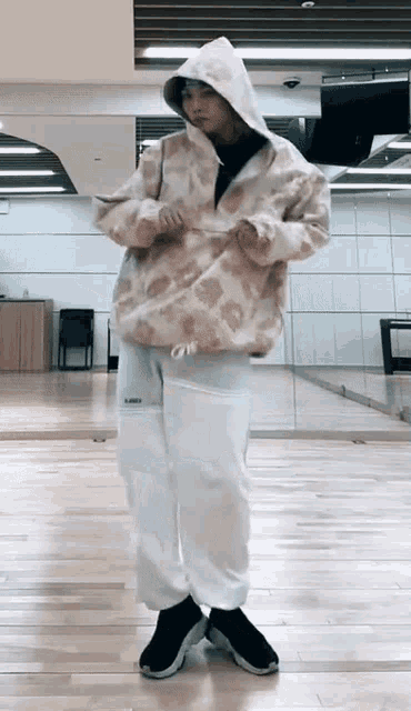 a person wearing a hoodie and white sweatpants