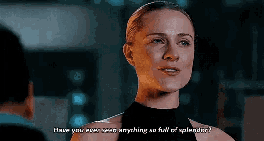 a woman in a black top is talking to a man in a dark room .