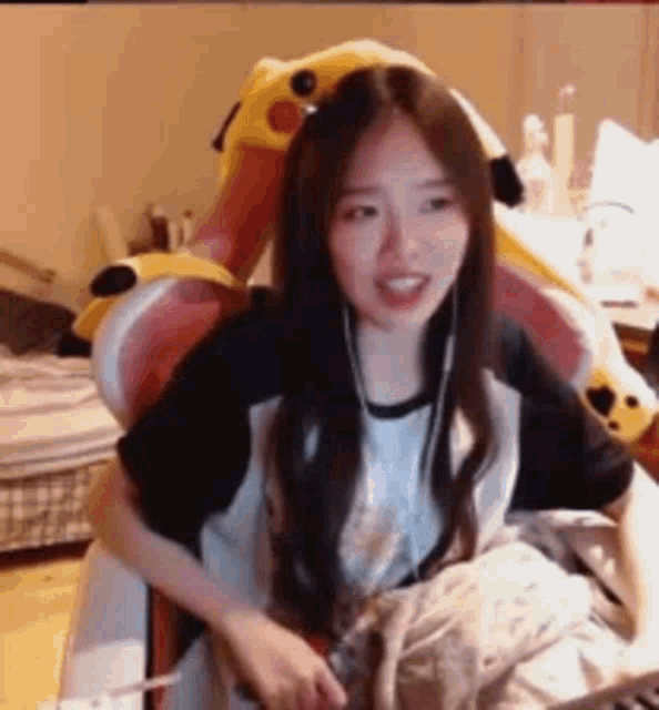 a woman is sitting in a chair with a stuffed animal behind her head .