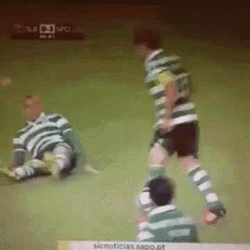 a soccer game is being played on a green field with a sign that says sicnoticias sapo.pt on it