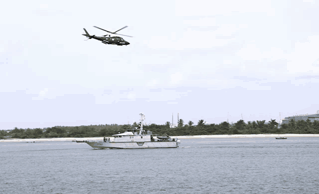 a helicopter is flying over a boat in the ocean