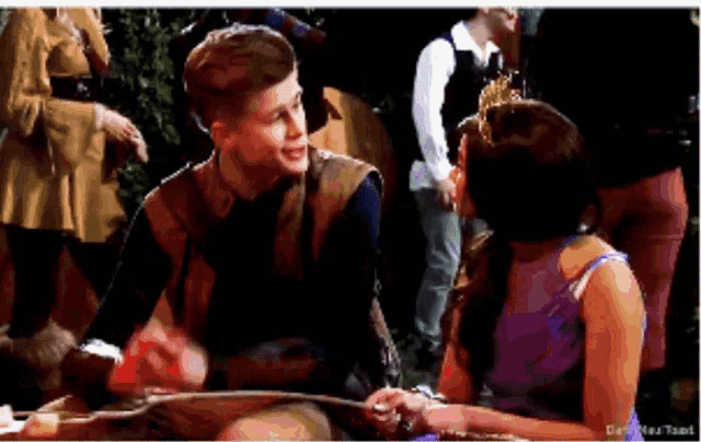 a man and a woman are sitting next to each other and holding hands