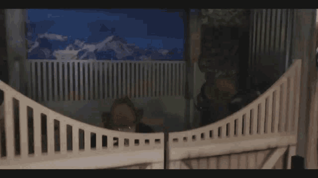 a man in a cowboy hat is behind a fence