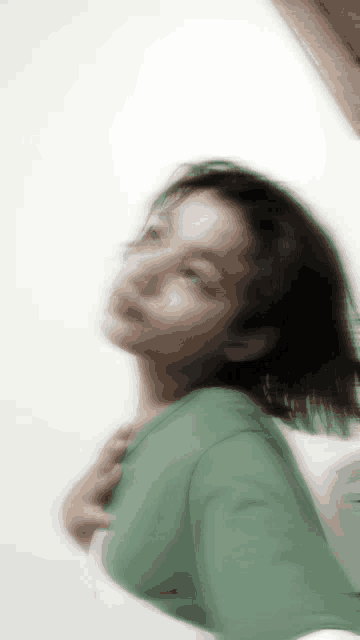 a blurry picture of a girl with a green shirt on