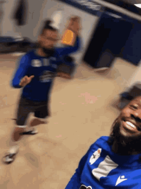 a blurry picture of a man wearing a blue shirt that says sbc