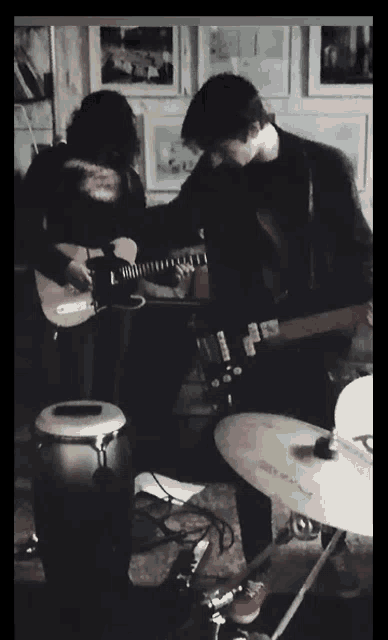 a man playing a guitar in front of a drum set with a cymbal that says ' pioneer ' on it