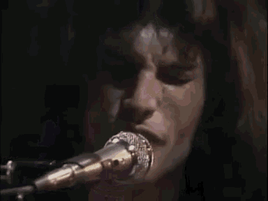 a close up of a woman singing into a microphone