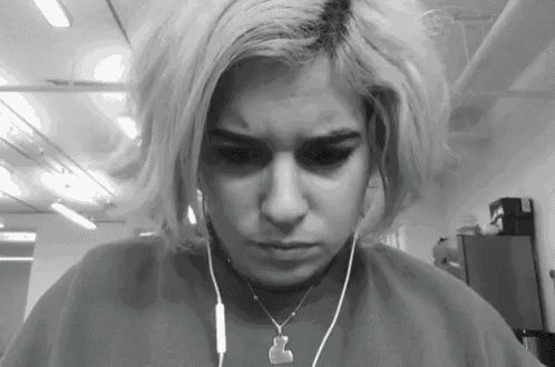 a woman wearing headphones and a necklace with a gummy bear pendant