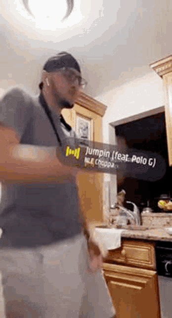 a man is dancing in a kitchen while wearing headphones and a headband .