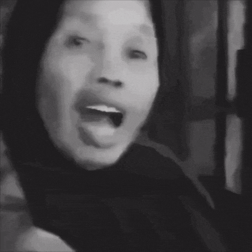 a black and white photo of a person with their tongue out