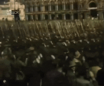 a crowd of people are gathered in front of a building with the number 24 ack on the bottom