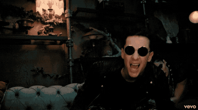 a man in a black leather jacket is singing in a video that is sponsored by vevo