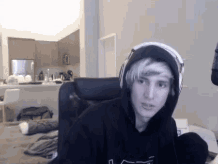a young man wearing headphones and a black hoodie with the letter l on it
