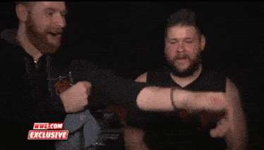 two men are standing next to each other with wwe.com exclusive written on the bottom of the screen