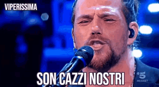 a man singing into a microphone with the words son cazzi nostri on the bottom .