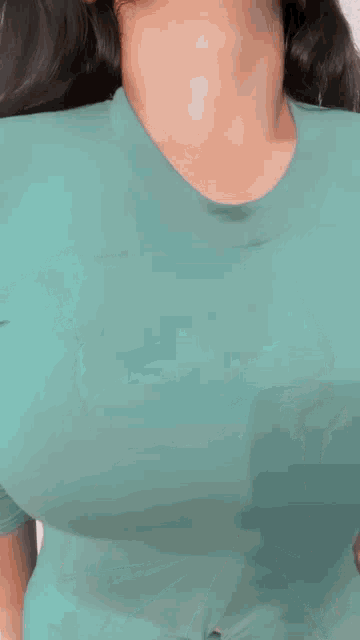 a woman is wearing a teal crop top with a knot in the middle